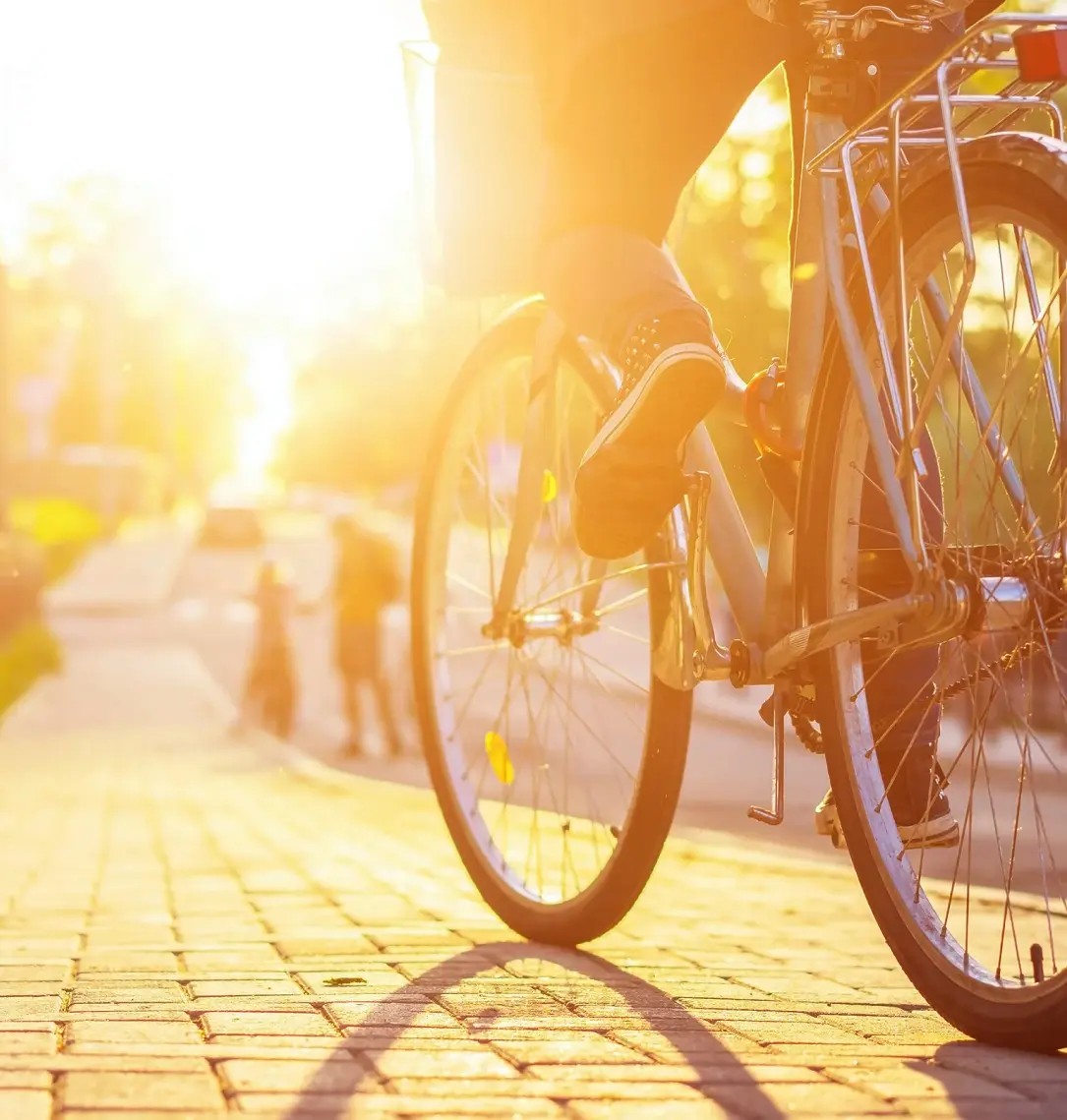 Cyklist på gata i solljus